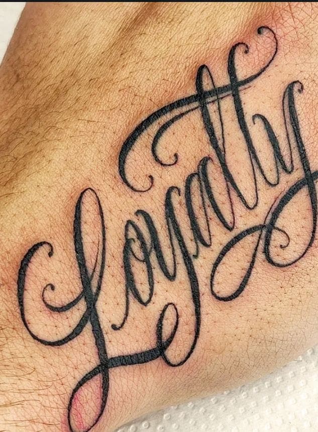 Elegant Script Loyalty Forearm Tattoo