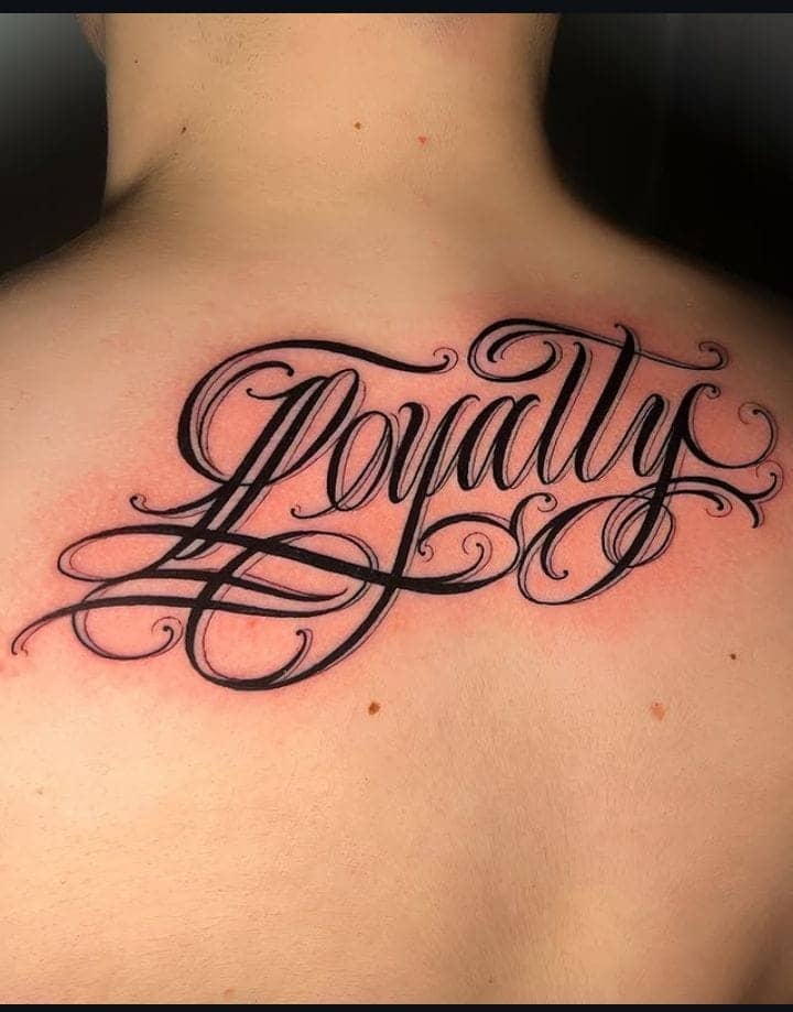 Elaborate Script Loyalty Back Tattoo 